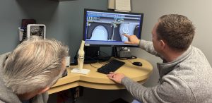 Orthopedic doctor with a patient, showing them xrays on a computer screen